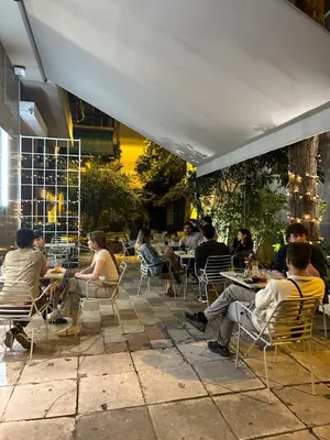 a group of people sitting at tables on a patio at Cozy apartment National Museum in Athens