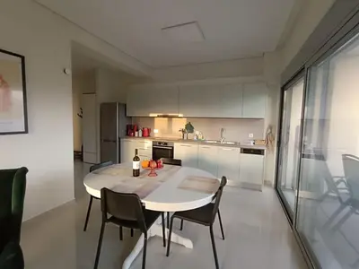 a kitchen with a table and chairs in a room at Ein Appartement zum wohlfühlen in Anavissos