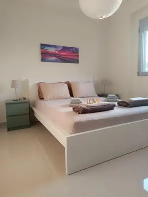 a large white bed in a white room at Ein Appartement zum wohlfühlen in Anavissos