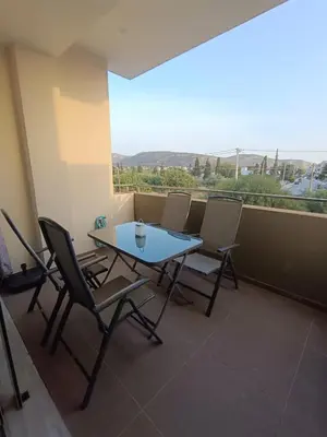 a table and chairs on a balcony with a view at Ein Appartement zum wohlfühlen in Anavissos