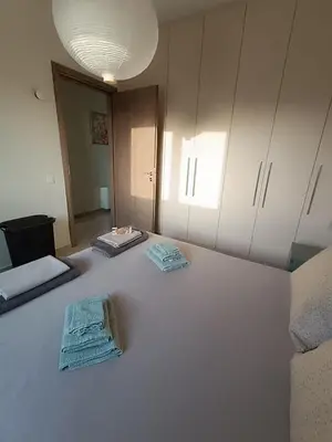 a room with a large bed with towels on it at Ein Appartement zum wohlfühlen in Anavissos