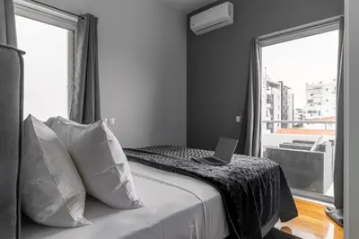 a bedroom with a bed with a laptop on it at Downtown Glyfada Riviera Eclipse in Athens