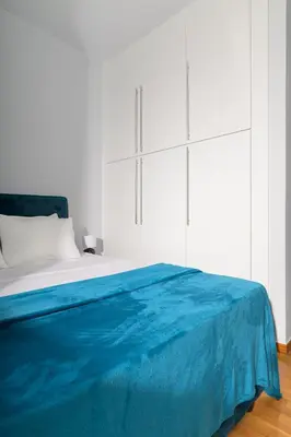 a bedroom with a blue blanket on a bed at Downtown Glyfada Riviera Eclipse in Athens
