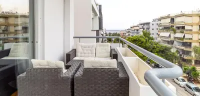 a balcony with two chairs and a view of a city at Downtown Glyfada Riviera Eclipse in Athens
