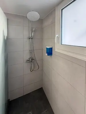 a shower in a bathroom with a window at Downtown Glyfada Riviera Eclipse in Athens
