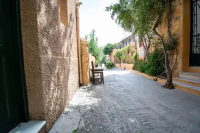 an empty alley with a bench next to a building at Anafiotika FOS Cycladic Home! in Athens