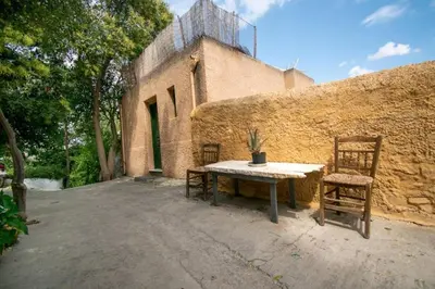 a table and two chairs sitting next to a wall at Anafiotika FOS Cycladic Home! in Athens