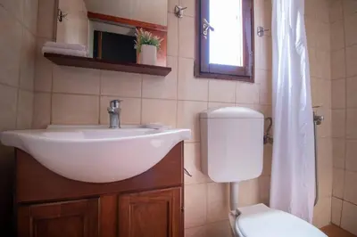 a bathroom with a sink and a toilet at Anafiotika FOS Cycladic Home! in Athens