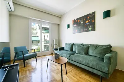 a living room with a green couch and a table at Spacious 3 Bedroom Flat at Metro in Athens