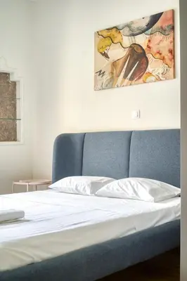 a bed with a blue couch in a room at Spacious 3 Bedroom Flat at Metro in Athens