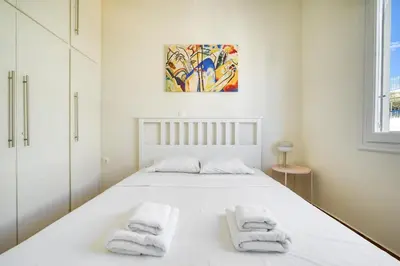 a white bedroom with a bed with towels on it at Spacious 3 Bedroom Flat at Metro in Athens