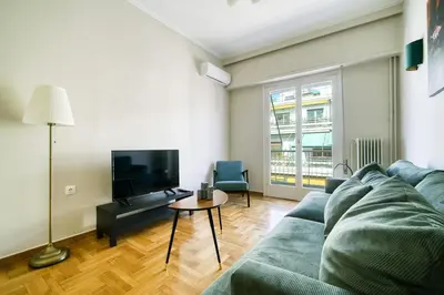 a living room with a blue couch and a tv at Spacious 3 Bedroom Flat at Metro in Athens