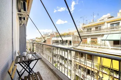 a balcony with a table and a view of buildings at Spacious 3 Bedroom Flat at Metro in Athens