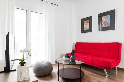 a red couch in a living room with a table at Bohemian Chic in the Heart of Athens in Athens