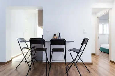 a kitchen with four black chairs and a table at Bohemian Chic in the Heart of Athens in Athens
