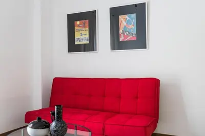 a red couch in a living room with a table at Bohemian Chic in the Heart of Athens in Athens