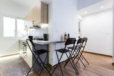 a kitchen with a counter and chairs in a room at Bohemian Chic in the Heart of Athens in Athens
