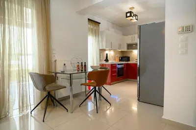 a kitchen with a table and chairs in a room at Athenian Riviera Prestige 2 bedroom in Athens