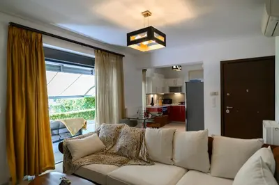 a living room with a white couch and a large window at Athenian Riviera Prestige 2 bedroom in Athens