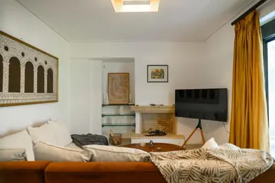 a living room with a couch and a tv at Athenian Riviera Prestige 2 bedroom in Athens