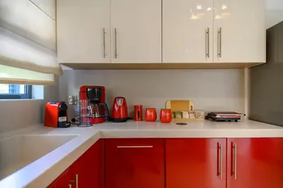 a kitchen with red cabinets and red appliances at Athenian Riviera Prestige 2 bedroom in Athens