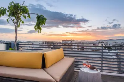 a couch on a balcony with a glass of wine at Acropolis View Luxe Penthouse with Outdoor Terrace HotTub in Athens