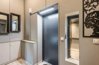 a metal elevator in a room with a window at Acropolis View Luxe Penthouse with Outdoor Terrace HotTub in Athens