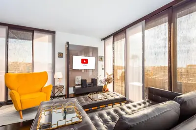a living room with a couch and a yellow chair at Acropolis View Luxe Penthouse with Outdoor Terrace HotTub in Athens