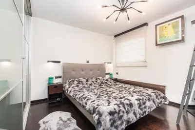 a bedroom with a bed and a chandelier at Acropolis View Luxe Penthouse with Outdoor Terrace HotTub in Athens