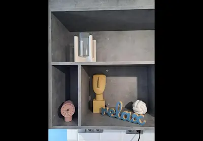a shelf with a doll house with a clock and a radio at Agatha-1 in Piraeus