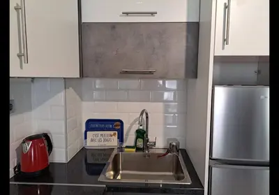 a kitchen with a sink and a stainless steel refrigerator at Agatha-1 in Piraeus
