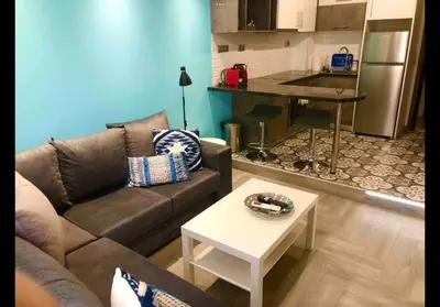 a living room with a couch and a table and a kitchen at Agatha-1 in Piraeus
