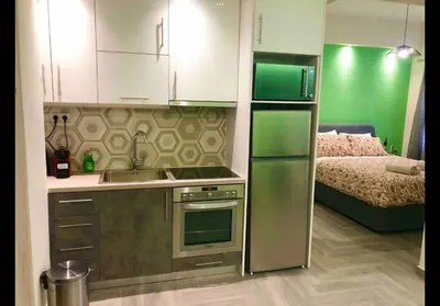 a kitchen with a sink and a refrigerator and a bed at Agatha-2 in Piraeus