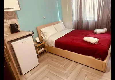 a bedroom with a bed with red sheets and white pillows at Agatha-3 in Piraeus