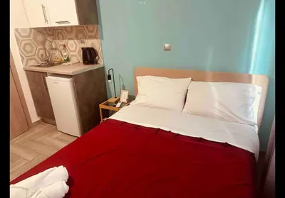 a bed in a small room with a red blanket at Agatha-3 in Piraeus