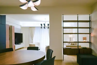 a living room with a dining room table and a bedroom at Sophisticated Living ,Balcony & Stunning Interior in Athens