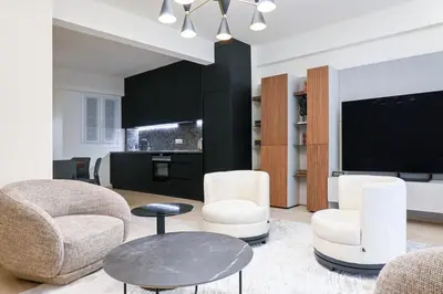 a living room with chairs and a flat screen tv at Sophisticated Living ,Balcony & Stunning Interior in Athens
