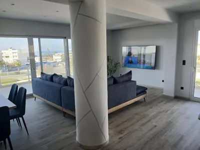 a living room with two blue couches and a white column at Utopia Suit in Athens