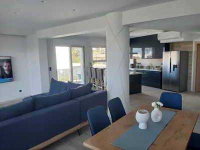 a living room with a blue couch and a table at Utopia Suit in Athens