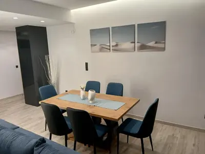 a dining room with a wooden table and blue chairs at Utopia Suit in Athens