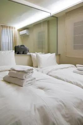 a group of white beds in a room at Refined Kolonaki Stay ,Private Patio & Stylish Comfort in Athens