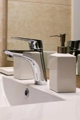 a bathroom sink with a faucet and a soap dispenser at Refined Kolonaki Stay ,Private Patio & Stylish Comfort in Athens