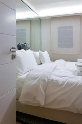 a large white bed in a room with a window at Refined Kolonaki Stay ,Private Patio & Stylish Comfort in Athens