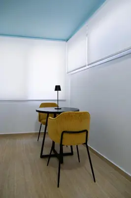 a table and chairs in a room with a white wall at Refined Kolonaki Stay ,Private Patio & Stylish Comfort in Athens