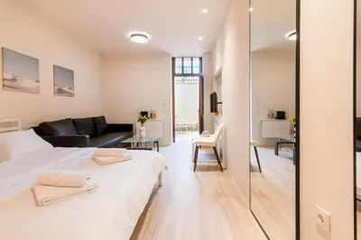 a bedroom with a large white bed and a living room at A36 Gateway to Plaka 400m 2 Syntagma Sunny patio in Athens