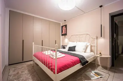 a bedroom with a white bed with a red blanket at Duplex in Gazi with Acropolis view in Athens