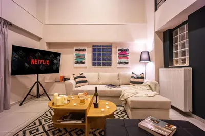 a living room with a couch and a tv at Duplex in Gazi with Acropolis view in Athens