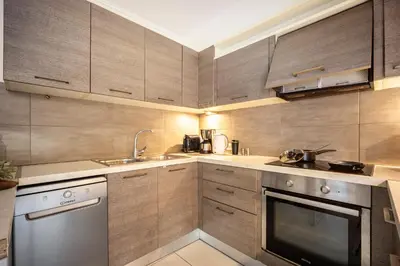 a kitchen with wooden cabinets and a sink and a dishwasher at Duplex in Gazi with Acropolis view in Athens