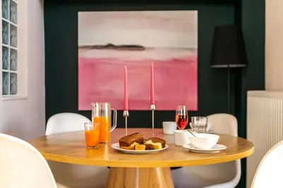 a table with a plate of food and drinks on it at Duplex in Gazi with Acropolis view in Athens