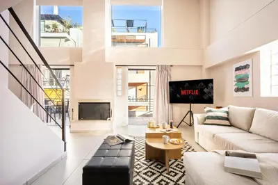 a living room with a couch and a tv at Duplex in Gazi with Acropolis view in Athens